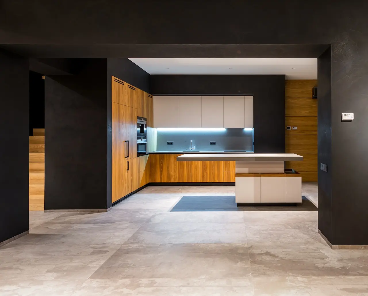 آشپزخانه ای که به سبک جدید با طرح چوب میباشد و کف پوش سنگی نیز روی زمین است